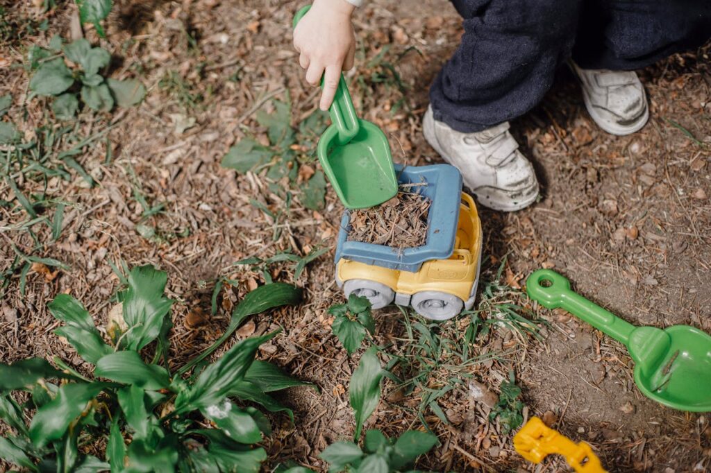 Crop kid playing with sand shovel